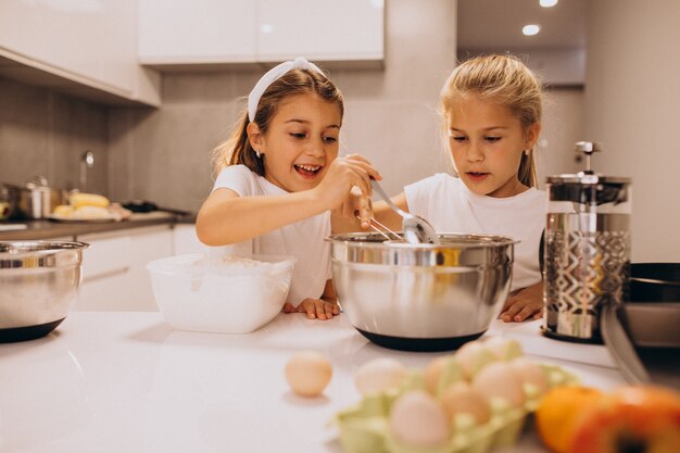 キッチンで料理をする2人の少女姉妹