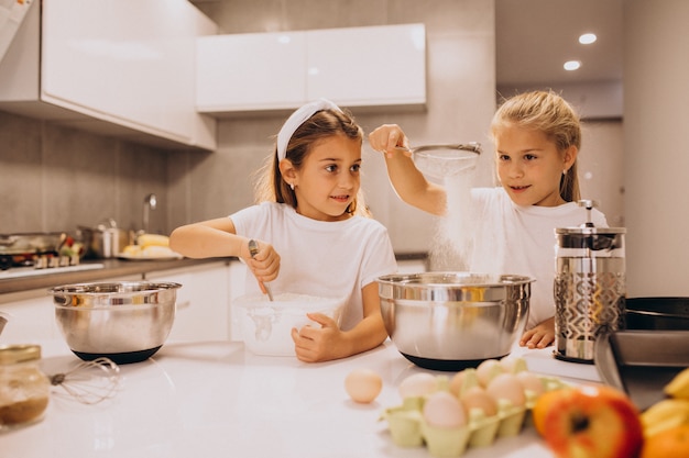 Two little girls sisters cooking at kitchen