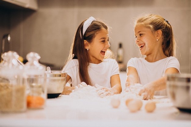 Two little girls sisters cooking at kitchen