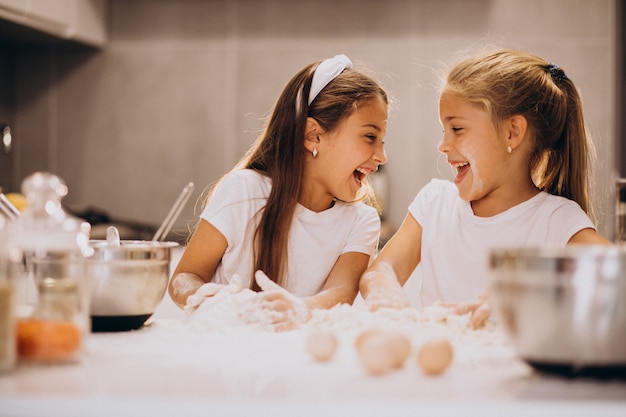 Two little girls sisters cooking at kitchen