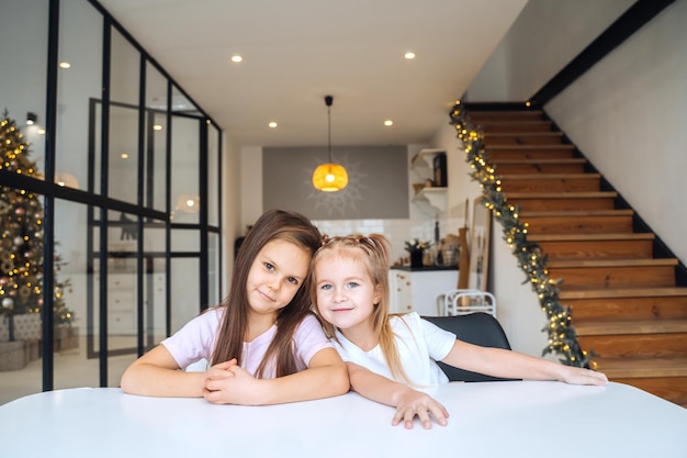 Two little girls at the table looking at the camera closeup