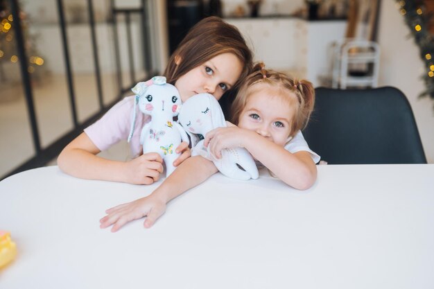 Two little sisters playing together at the table