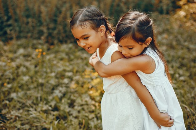 Two little sisters in a summer park