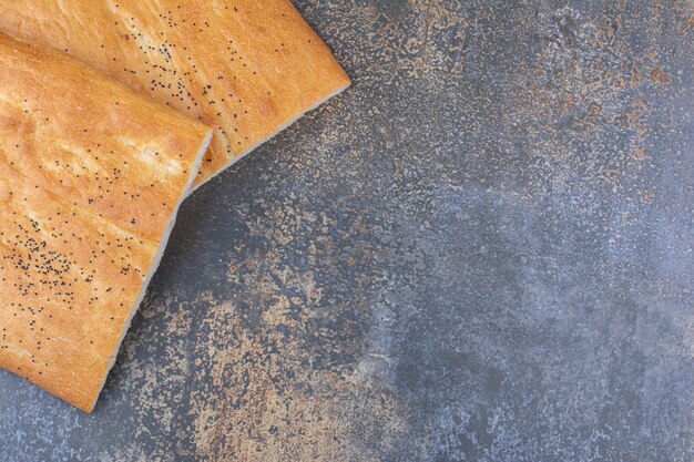 大理石の表面にカリカリに半分スライスしたタンドリーパンの2つのパン