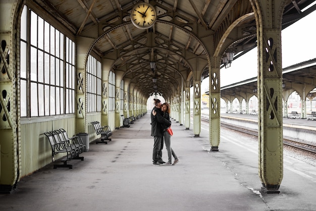 Two lovers hug and kiss on the railway station