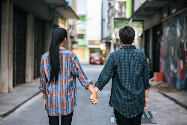 Two loving women standing and holding hands on the street.