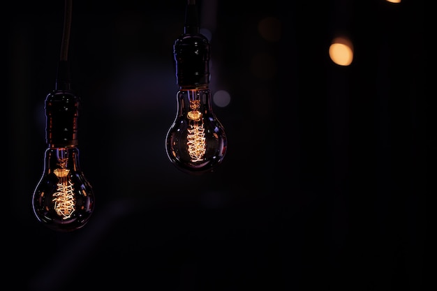 Two luminous lamps hang in the dark from the boke. Decor and atmosphere concept.