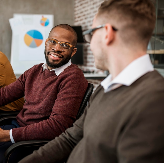 Two male colleagues talking to each other during a meeting