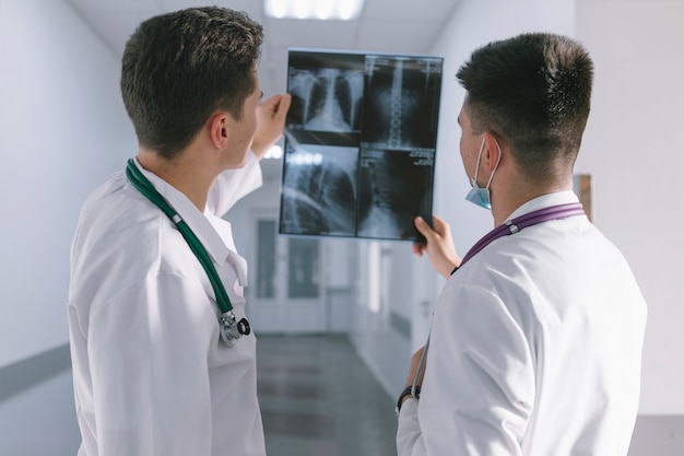 Два врача-мужчины, глядя на рентгеновский снимок