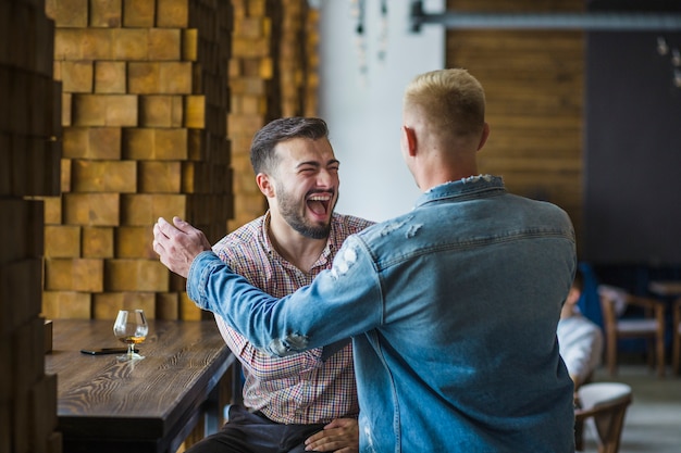 Two male friends having fun in the restaurant