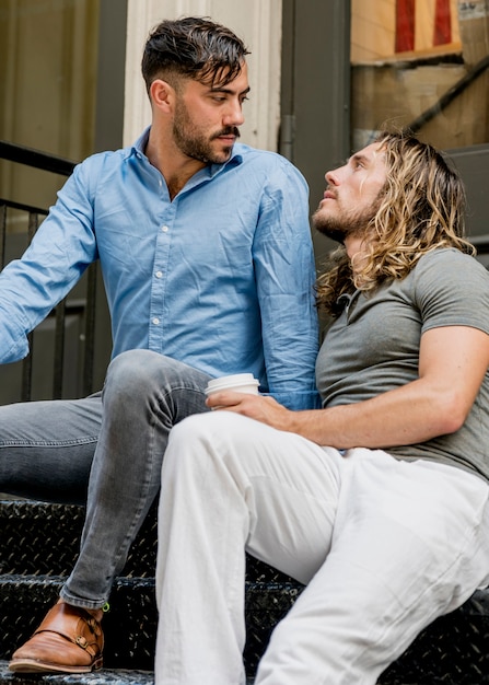 Two male friends sitting on stairs