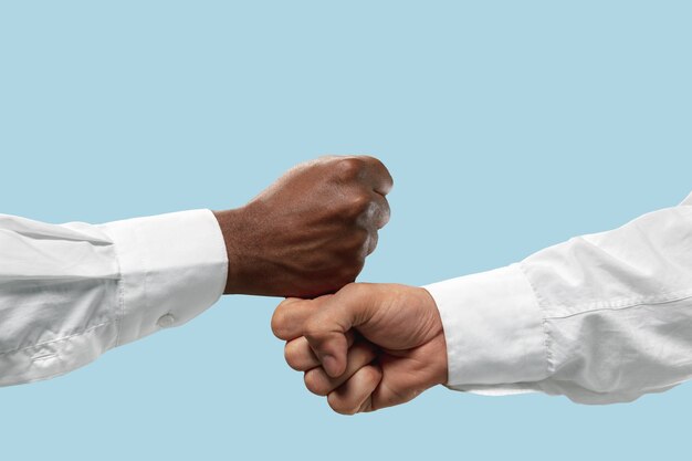 Two male hands competition in arm wrestling isolated on blue.