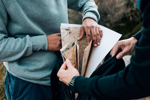 Two male hiker looking for map in the backpack