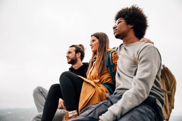 Two male hiker sitting with their female friend