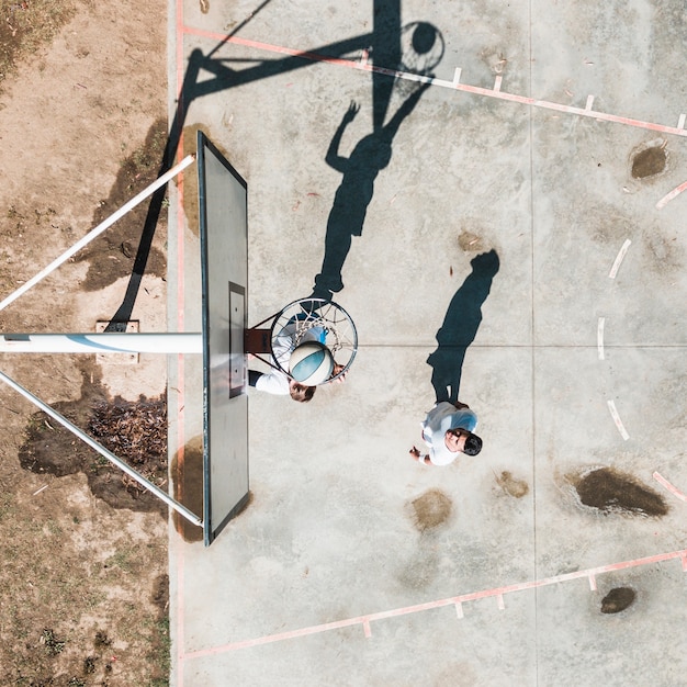 Two male player practicing with ball at outdoors court