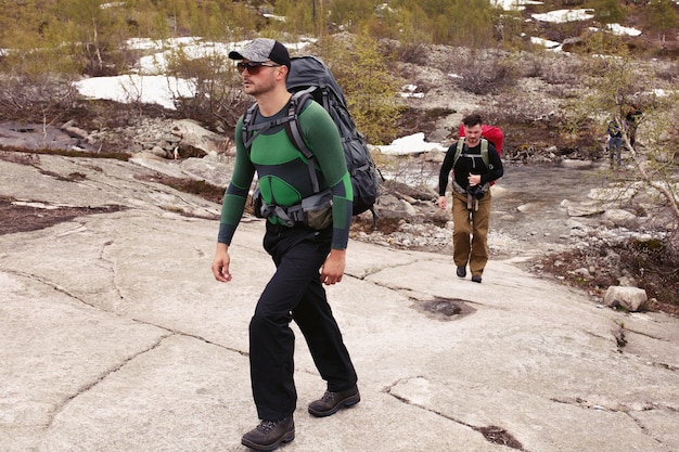 Two man walk on the rocks in the mountains 