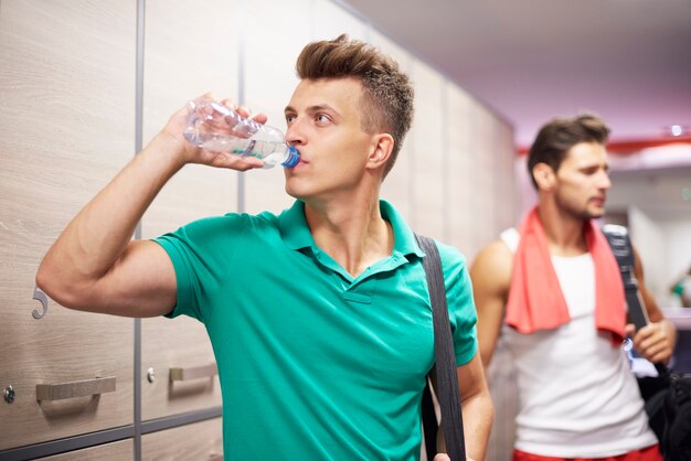 Two men in dressing room at gym