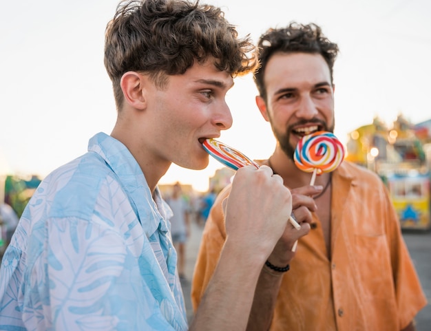 Two men enjoying lollipop outdoor
