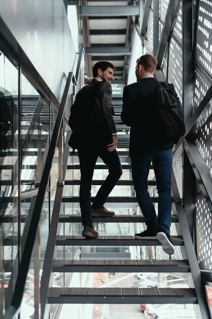 Two men going up, down stairs while chatting