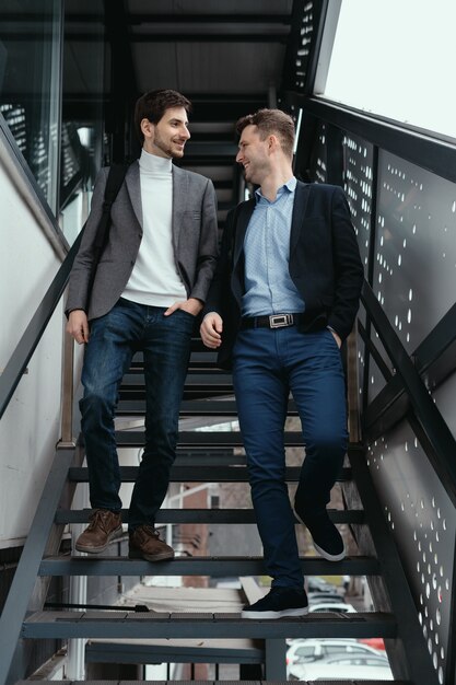 Two men going up, down stairs while chatting