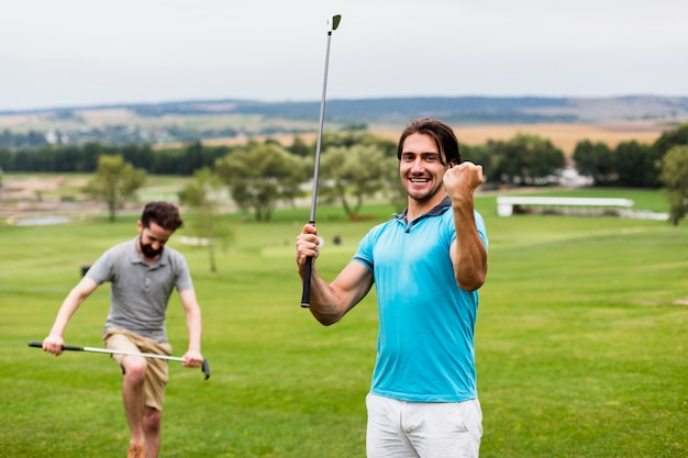 Двое мужчин веселятся на поле для гольфа