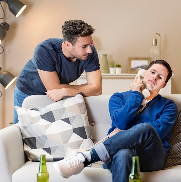 Free photo two men at home posing with telephone