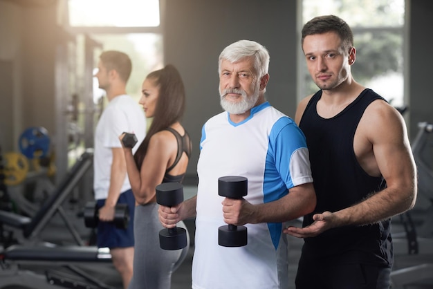 Free photo two men looking at camera while training in gym