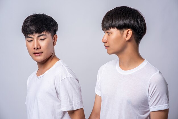 Two men in love wearing white t-shirts looked at each other's faces.