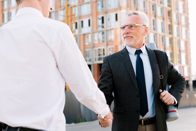 Two men shaking hands outdoors