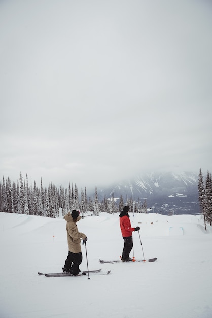 Two men skiing on snowy alps in ski resort