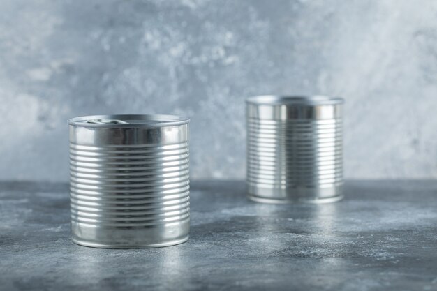 Two metallic cans on marble.