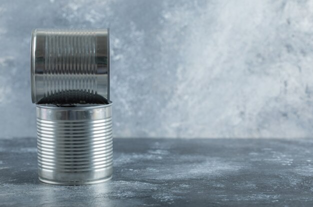 Two metallic cans on marble.