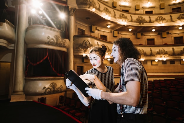 Free photo two mime artist reading manuscript on stage