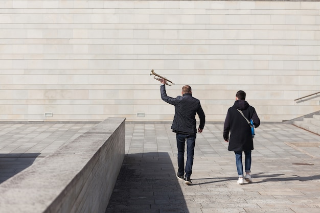 Due musicisti che camminano in ambiente concreto