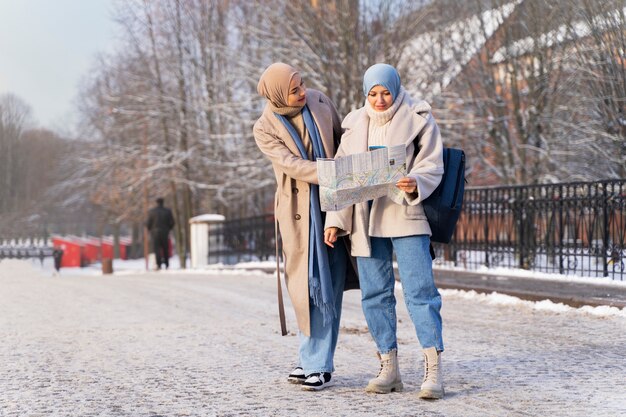 Две подруги-мусульманки консультируются с картой во время путешествия по городу