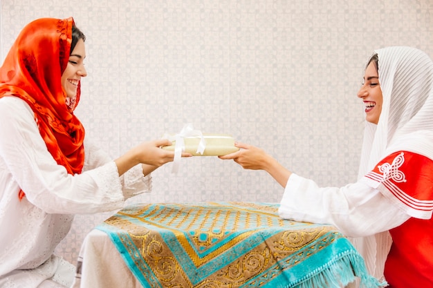 Free Photo two muslim women sitting at table