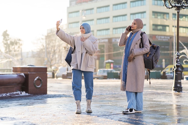 여행하는 동안 셀카를 찍는 두 이슬람 여성