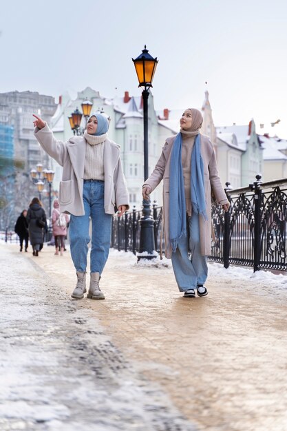 Two muslim women with hijabs looking around while visiting the city