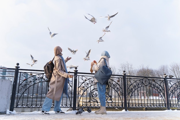 無料写真 旅行中に鳩を見ているヒジャーブを持つ2人のイスラム教徒の女性