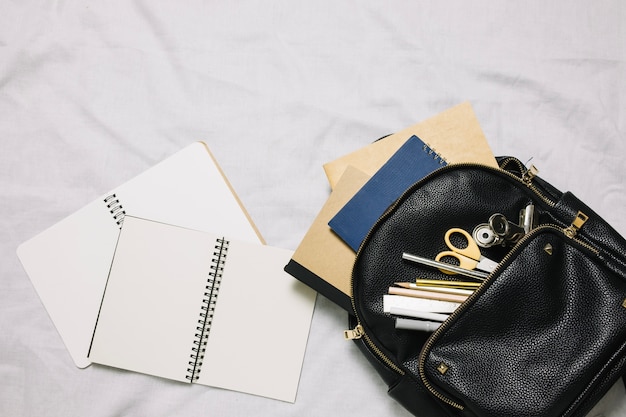 Two netebooks and bag with office supplies