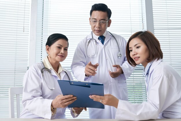 Free Photo two nurses reporting to the chief doctor