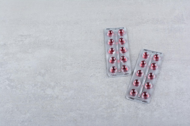 Two packs of red drugs on marble surface. High quality photo