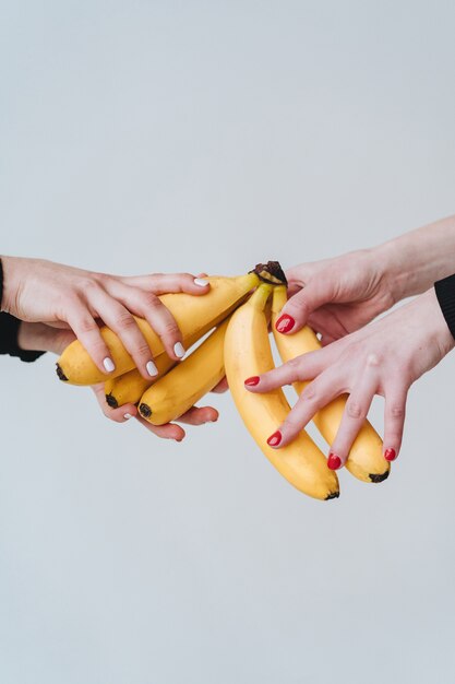 몇 바나나를 들고 손 두 켤레