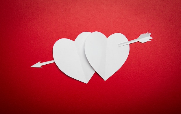 バレンタインの日のための矢印記号が貫通二つの紙の心