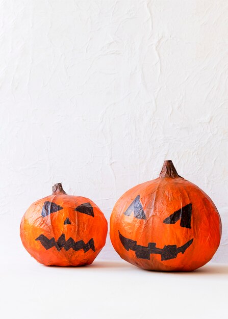 Two paper jack-o-lanterns on table