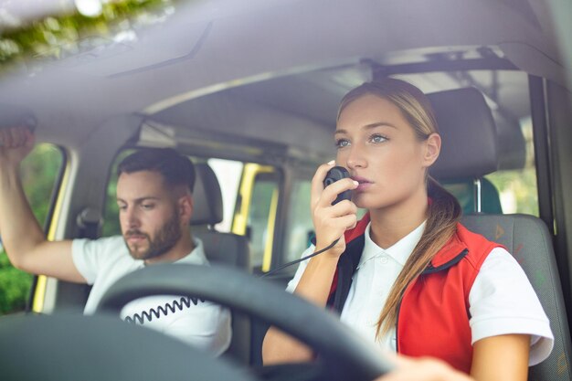 Free photo two paramedics int the ambulance female paramedic driving ambulance talking over the radio urgent situation