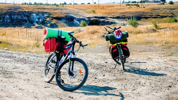 Two parked bicycles with traveler's stuff on a country road, ravine and fields in Moldova