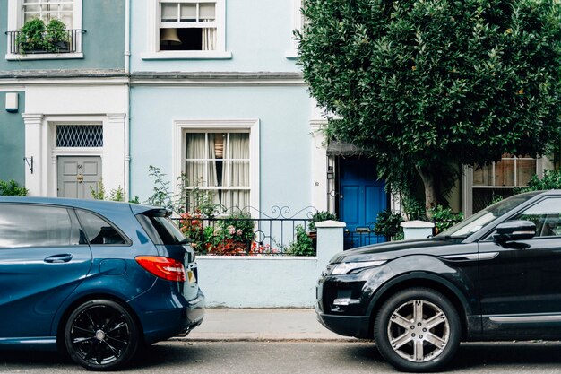 Two parked cars in front of an apartment entrance