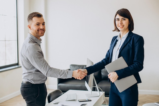 Two partners shaking hands in office