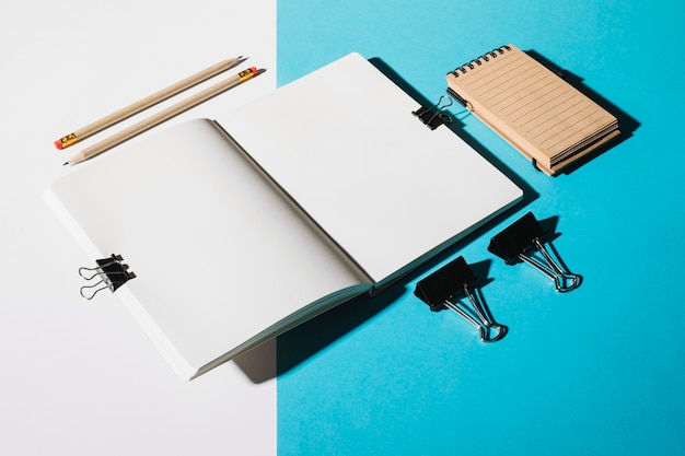 2本の鉛筆。ブルートゥースクリップとスパイラルノートパッドでノートブックを開く
